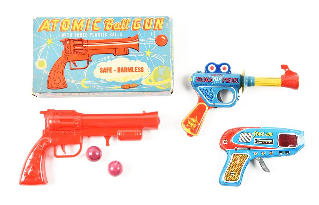 LOT OF 3: TIN LITHO & PLASTIC SPACE PISTOLS.: One in the original box, one Miss Daisy, one is a Japanese Space gun that is friction and not working, and the last one is an American Atomic Ball gun, which includes all three plastic balls. Conditio
