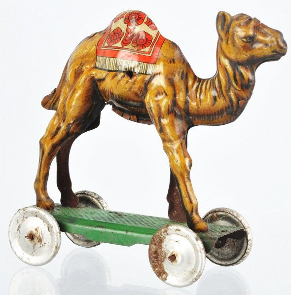 Tin Litho Camel on Platform Nickel Toy.: Description German. Marked "Made in Germany" on bottom of camel. Possibly missing its rider. Oxidation to silver wheels. Condition (Good - Very Good). Size 3 - 3/4" T.