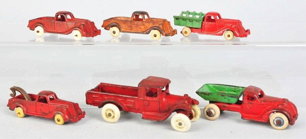 Lot of 6: Cast Iron Vehicle Toys.: Description American. Various small trucks include dump, stake back, and tow. A few have replacement white rubber tires. Condition (Very Good). Size Largest: 5" L.
