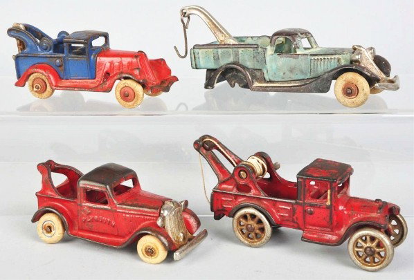 Lot of 4: Cast Iron Tow Truck Toys.: Description American. Various makers. One marked "Plymouth" on doors and another with an Arcade sticker on doors. Some paint loss and wear overall. One truck is missing its back two tires. Condition (