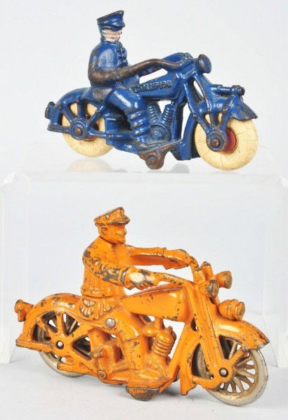 Lot of 2: Cast Iron Motorcycle Toys.: Description American. Includes one Champion with police rider and white rubber tires and one Hubley with nickel wheels and "Harley Davidson" on gas tank. Some paint loss and wear, especially to arms.