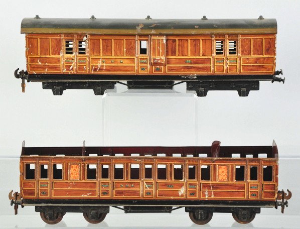 Lot of 2: Carette 1-Gauge Passenger Train Cars.: Description German. Both with wood-grain-effect sides. One is missing a roof and the other car is missing eight wheels. Some bending and denting to cars. Condition (Good - Very Good).