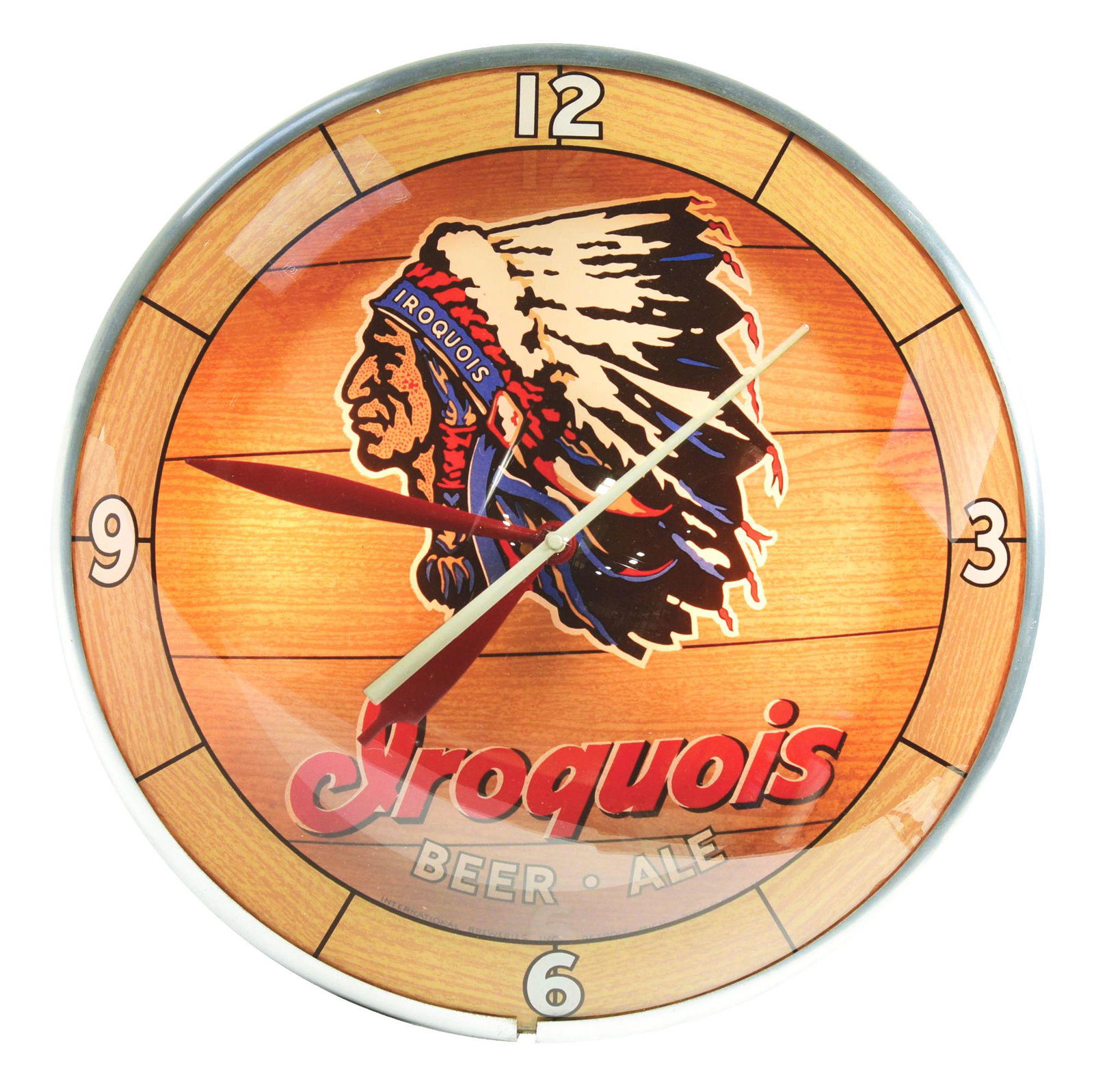 IROQUOIS BEER AND ALE LIGHT-UP CLOCK.: Double bubble Iroquois clock with painted wood grain glass, showing an iconic graphic Native American in full headdress. Label on the back reads "The Sign of Quality Advertising Products Incorporated,