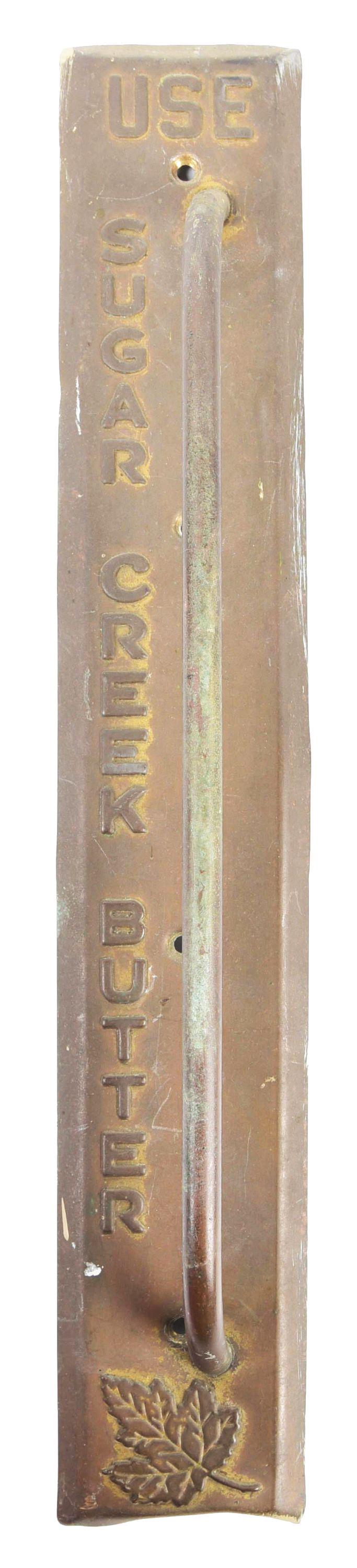 USE SUGAR CREEK BUTTER DOOR HANDLE.: Heavy metal embossed door push, reading "Use Sugar Creek Butter" with an embossed maple-type leaf at the bottom. CONDITION: There is a bend towards the bottom. Condition: (7.0). Dimensions: 3" x 2" x 