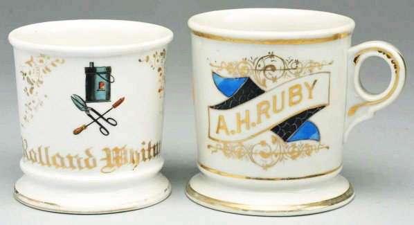 Lot of 2: Shaving Mugs.: Description Includes one tinsmith's mug with a set of sheers and poker gilded "Roland Whitman" and one with a nice scroll design gilded "A.H. Ruby" across front. Condition (Excellent Plus). Size Large