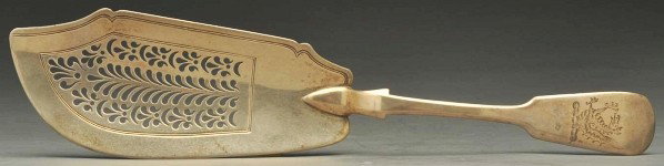 An English Silver Fish Slice.: Description William Chawner London 1832 Fiddle pattern with a pierced and engraved blade, the handle engraved with a crest. L 12-3/8 in.; 5 oz. Condition (Good). Size 12 - 3/8" L.