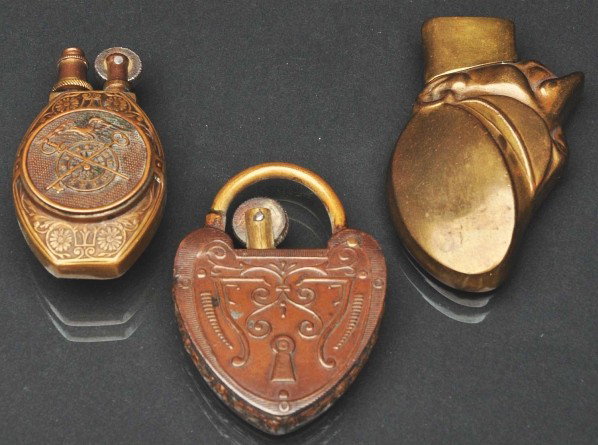 Lot of 3: Brass Trench Lighters.: Description Includes one in the form of a soldier, one lock, and one with an eagle, crossed swords, and US. All appear to be functional. Condition (Excellent). Size Largest: 2 - 1/2" T.