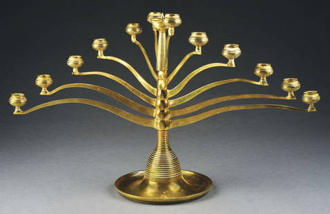 AFTER BRUNO PAUL 13-ARM BRASS CANDELABRUM.: C. 1906, USA. The candelabra features six arms that rotate and reticulate in pairs on base. Marked with "A" within a triangle and the monogram for the Anderson Brass Foundry. Condition: (Mint). Dimens