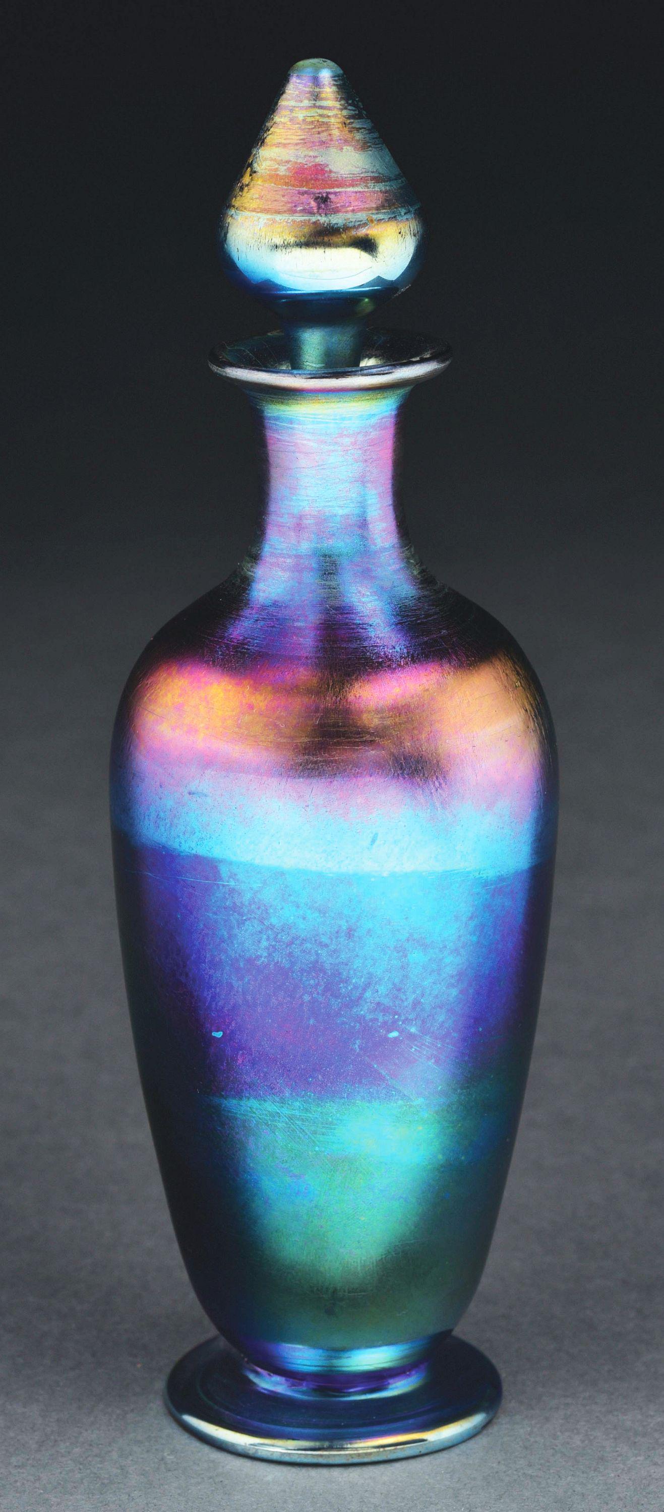 TIFFANY STUDIOS BLUE IRIDESCENT PERFUME BOTTLE.: Beautiful iridescent perfume bottle with stopper by Tiffany Studios. The 7 - 3/4" tall bottle with stopper is composed of beautifully iridescent favrile glass in shades of blue, purple and pink. Bottl