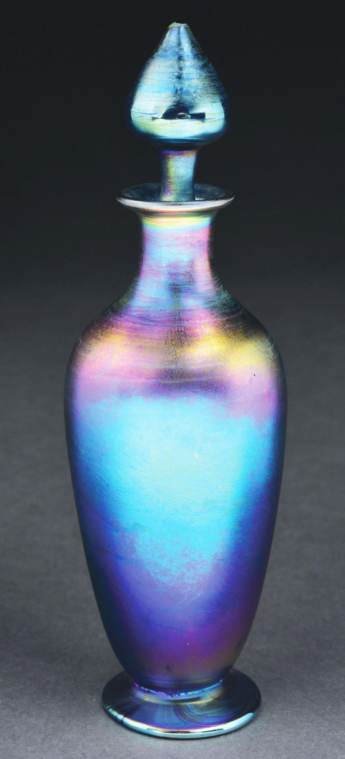 TIFFANY STUDIOS BLUE IRIDESCENT PERFUME BOTTLE W/ STOPPER.: Beautiful blue perfume bottle by Tiffany Studios. The 7 - 1/2" tall bottle with stopper is composed of gorgeous iridescent favrile glass in shades of blues, purples and golds. Includes matching stoppe