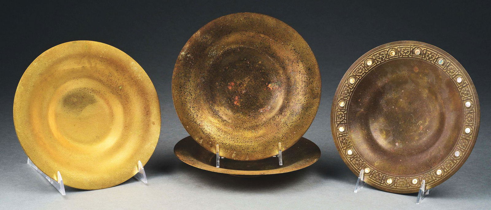 LOT OF 4: TIFFANY STUDIOS BRONZE BOWLS W/ ABALONE.: Lovely set of four bronze bowls/platters by Tiffany Studios. Each bowl measures 8 - 3/4" diameter. (A) Bowl has a pattern around the rim with a series of abalone discs, some of which have fallen off,