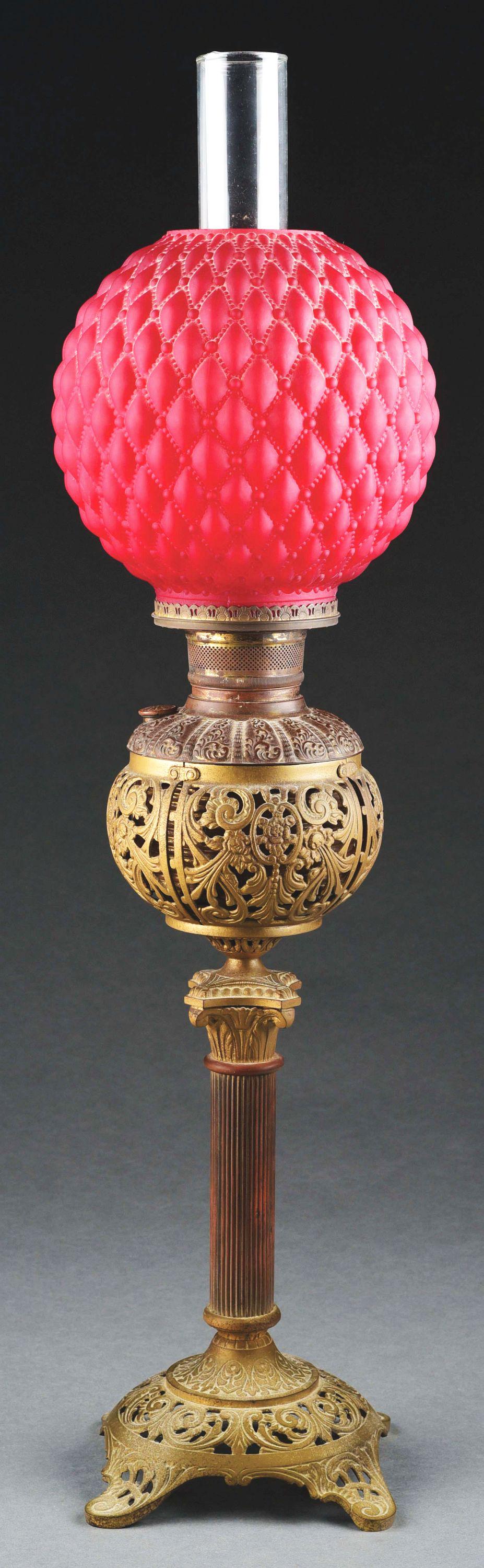 BRADLEY & HUBBARD OIL LAMP.: Lovely kerosene oil lamp by Bradley and Hubbard. The 8” diameter glass globe is made of beautiful red glass in a textured geometric pattern. Glass sits in a brass Bradley and Hubbard kerosene ta