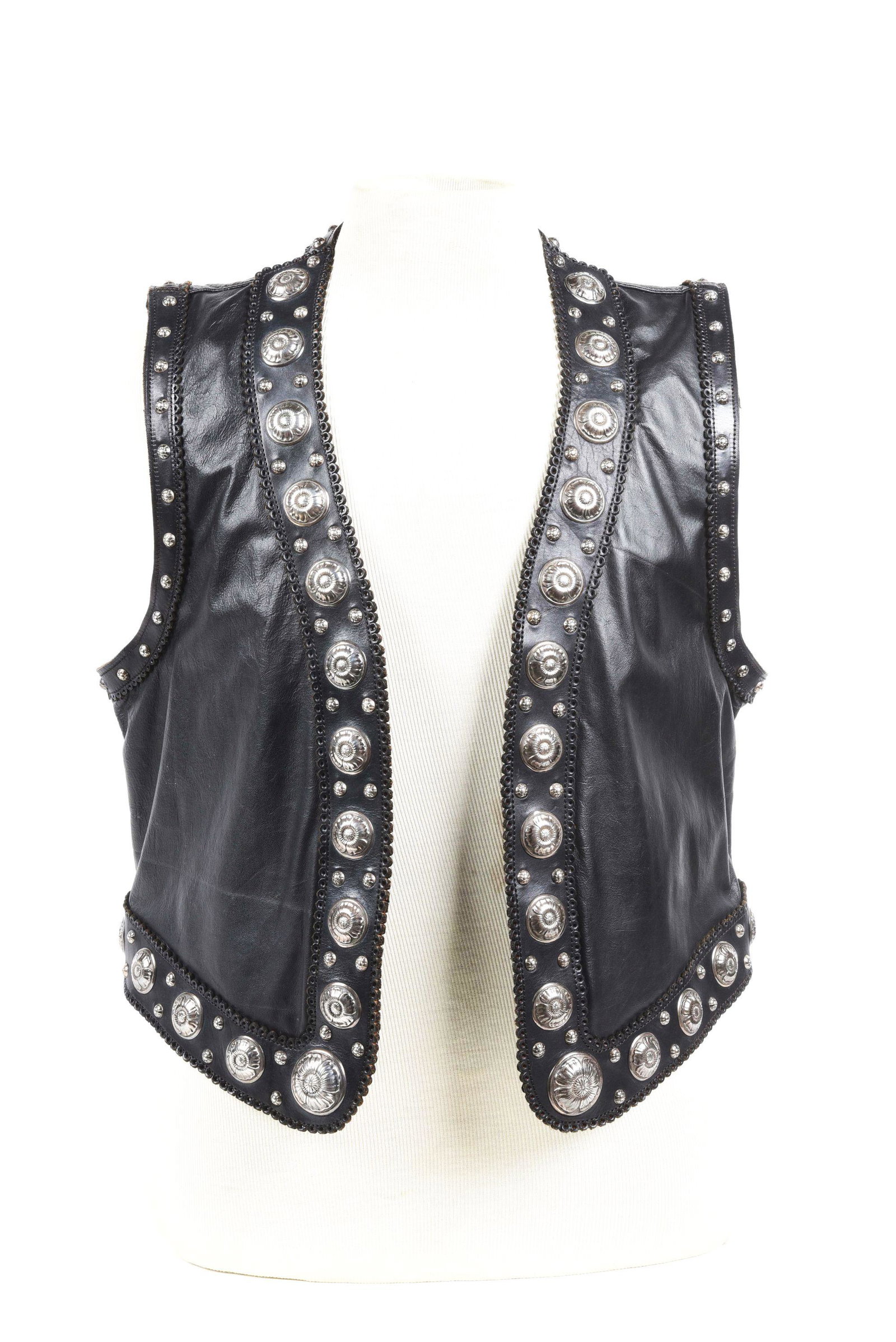 EDWARD H. BOHLIN, SAN FERNANDO VEST: A sterling silver decorated black leather vest. Made of soft calfskin and mounted with Edward H. Bohlin poppy conchos no. 446, 447, and 449 and intermixed with Bohlin spots. In fine wearable condition
