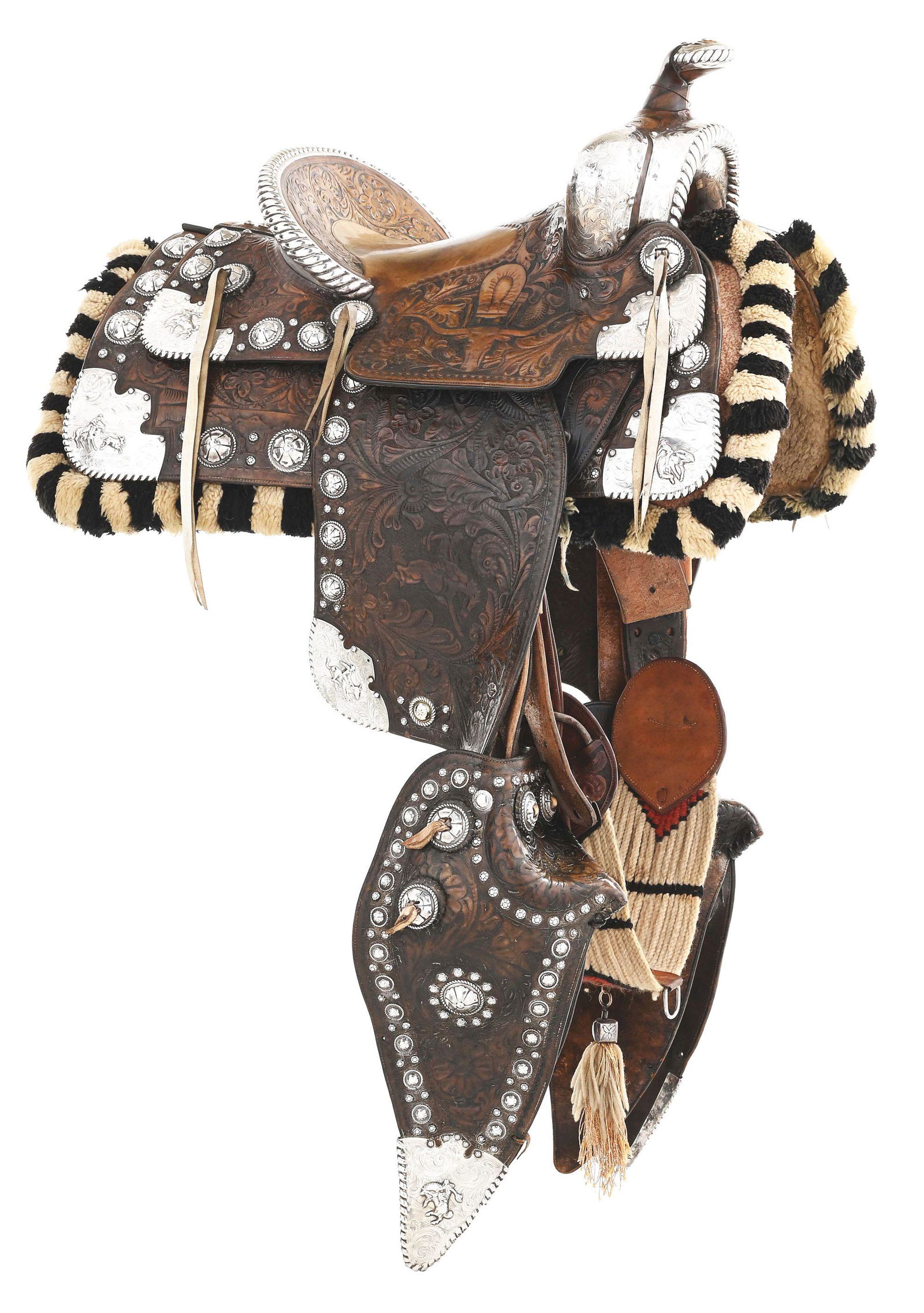 EDWARD H. BOHLIN STERLING FIGURUAL PARADE SADDLE: A fine circa 1930s two tone brown parade saddle with a 14 - 1/2" seat combining outstanding leather carving, silver engraving and silver conchos from several Bohlin catalog styles of that era includin