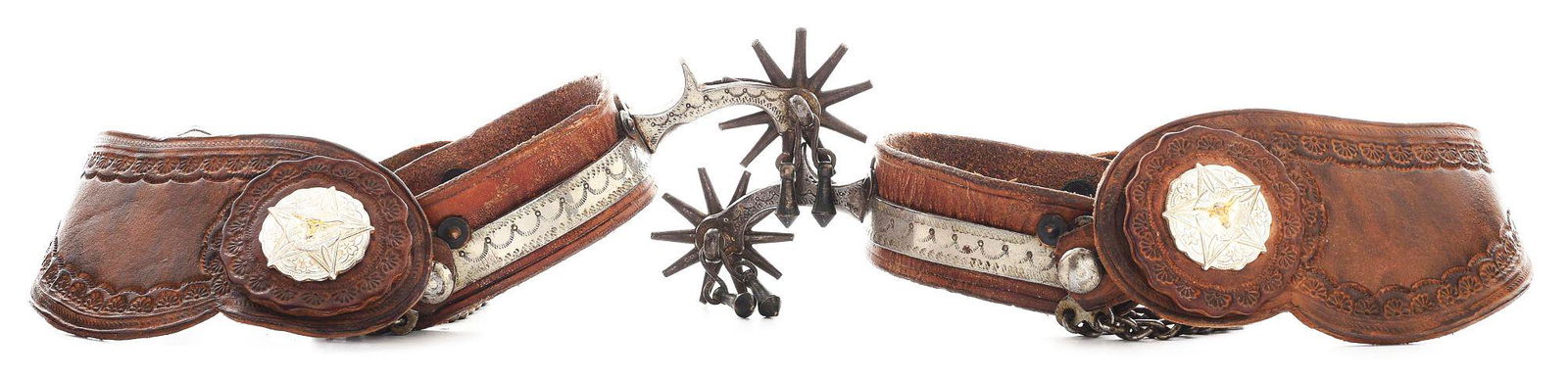 AUGUST BUERMANN SPURS: A pair of the early sheet steel "Leather Lined Cowboy Spurs" offered by August Buermann. Marked with the "Pat'd" and early star. The leather has been restored on this pair but retain the double chains