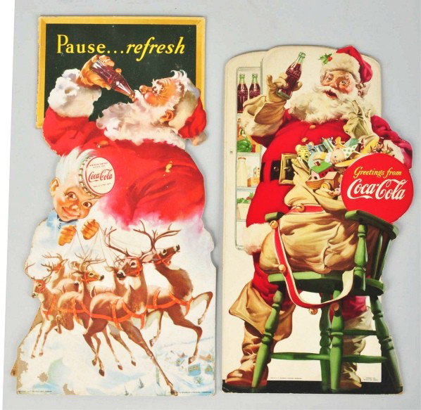 Lot of 2: Cardboard Coca-Cola Santa Cutouts.: 1948 and 1949. The 1948 cutout is bright with only light soiling and minor edge bends while the 1949 has some minor mildew spots, light stains, some surface color loss in lower left corner, and minor 