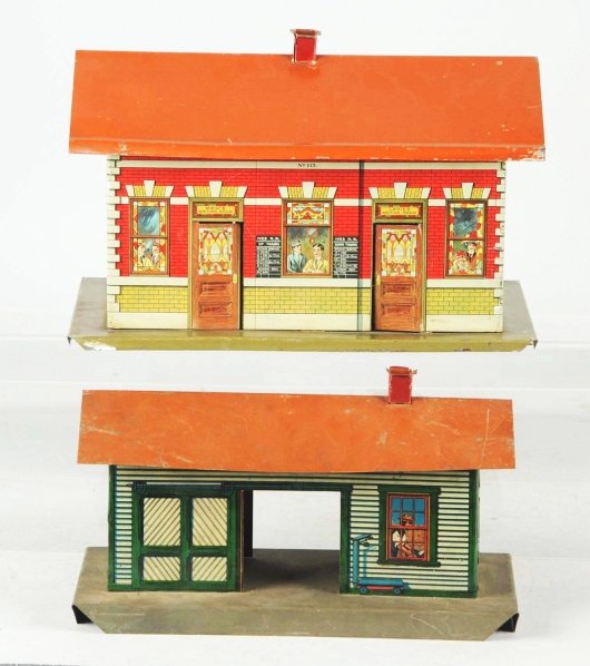 Lot of 2: Early Tin Litho Ives Train Stations.: American. Pre-war. Includes one freight station and one railroad station. Very nice lithography throughout with just some chipping and wear to bases and roofs. Condition (Very Good - Excellent).