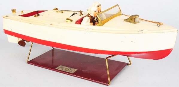 Tinplate Lionel Clockwork Motor Boat Toy.: American. Marked "Lionel-Craft" on rear plate. Original drivers and stand. Steering wheel has been replaced and one stanchion in back is missing. Stand has some scratching and wear. Condition (Very Go