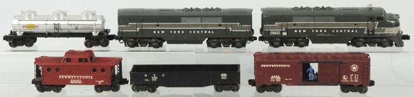 Lionel O-Gauge New York Central Freight Train Set: American. Post-war. Includes no. 2354 power unit with some paint flaking and damage to nose, no. 2344 B unit, and four freight cars consisting of one tank car, one Pennsylvania boxcar, one gondola car