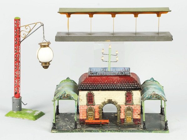 Lot of 2: Tin Train Stations.: German. Combination of hand-painting and lithography. Includes one Bing station and one small train platform. The Bing station has awnings on both sides and bench in front. Some moderate paint loss an