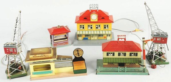Lot of 6: Tin Railroad Accessories.: German. Pre and post-war. Includes various stations and cranes along with one weighing scale. Condition (Very Good).