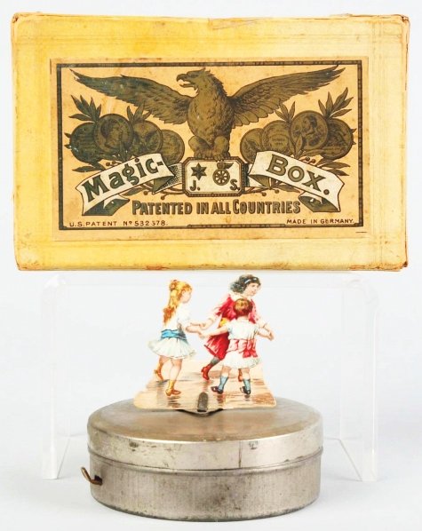Early Jean Schoenner Magic Box Toy.: German. Scarce. Tin base with cardboard figures of three dancing children. Figures have some creasing. Includes original box and instructions. Condition (Very Good - Excellent). Size Box: 5 - 3/4" L. 