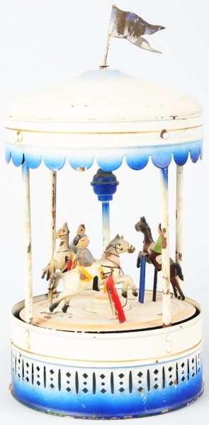Hand-Painted Tin Doll Company Carousel Toy.: German. Steam accessory version. Depicts three boys on articulated horses that move around pole when activated by wheel on side. Original flag on top. Some paint flaking to base and partially to a few