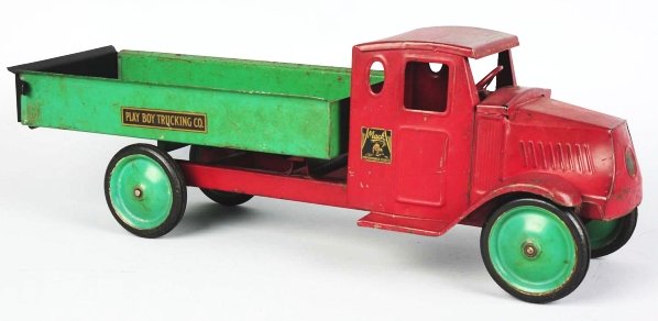 Pressed Steel Metalcraft Dump Truck Toy.: American. Solid disc wheels with rubber tires and original tailgate. Decals on back read "Playboy Trucking Company" and "Mack Junior Performance Counts" on sides. Some scratching and wear throughout, 