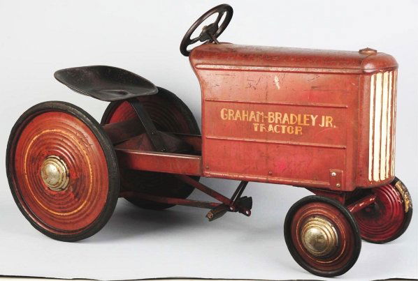 Pressed Steel Graham-Bradley Junior Pedal Tractor: This is one of the earlier and hard-to-find pedal car tractors. Appears to be in all original condition with rubber tires and "Graham-Bradley Junior Tractor" decals on both sides. Seat has some scratc