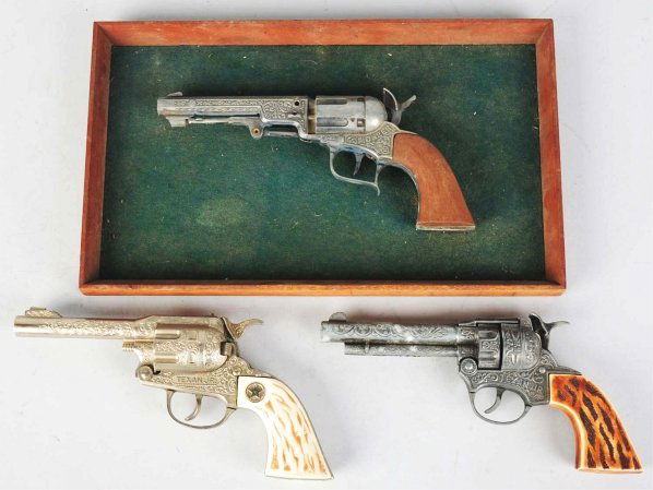 Lot of 3: Hubley Toy Cap Guns.: American. Includes one unusual Pioneer cap gun affixed to plaque, one Texas Junior with plastic grip, and one additional Texas Junior with plastic grip. Condition (Very Good). Size Largest: 9 - 1/2" L