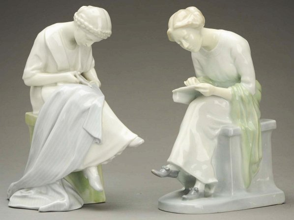 Pair of Heubach Figurines.: Glazed china finish in lovely pastel colors, elegant ladies are stamped with the green Gebruder Heubach square mark, both are seated at tasks, one trimming fabric with a pair of scissors and one readi
