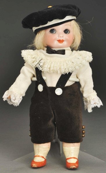 Darling German Googly Doll.: Bisque socket head incised “A 253 M NobbiKid U.S.Patent Germany 11/0” with blue glass side-glancing sleeping eyes, closed mouth with deep lips, antique blonde mohair wig; 5-piece papier-mâché bo