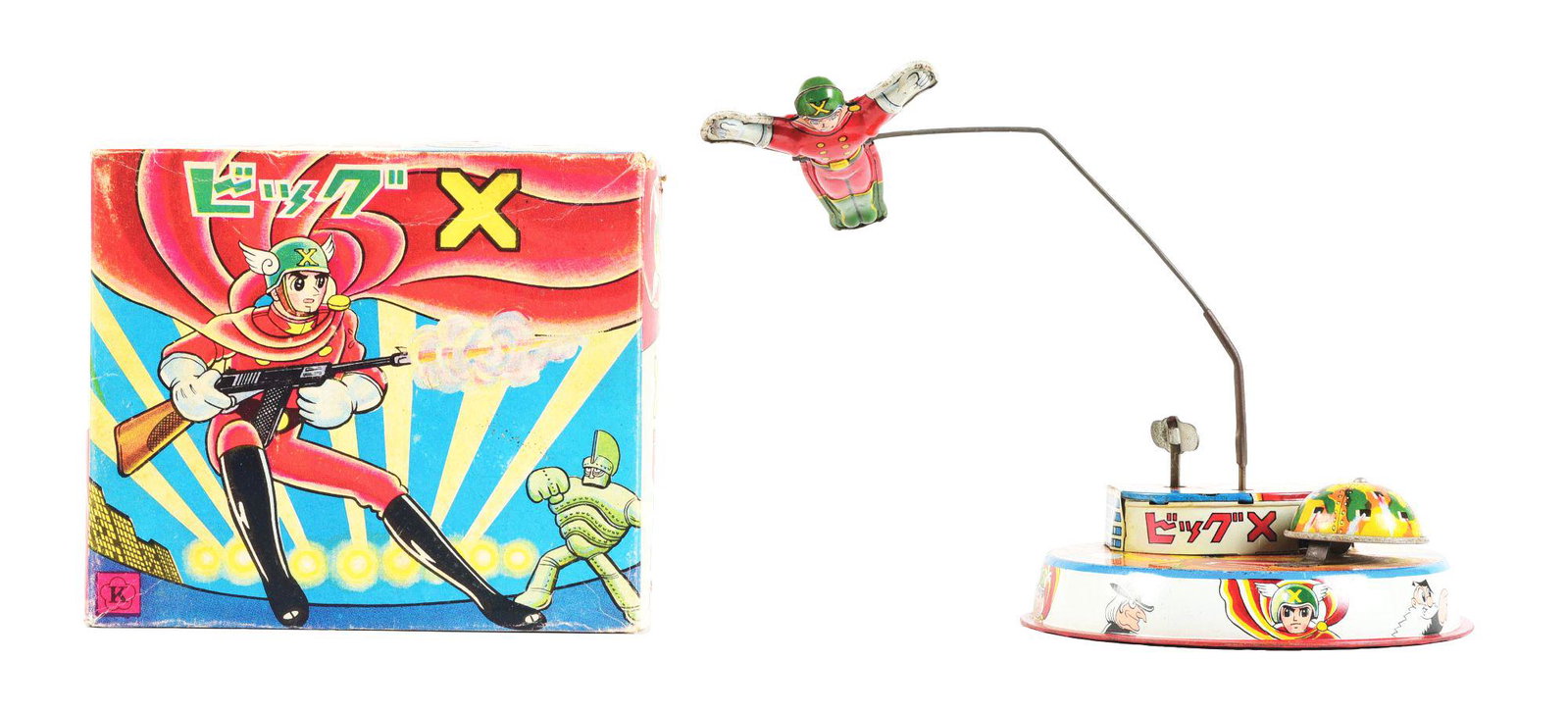 JAPANESE TIN LITHO WIND-UP BIG X TOY IN ORIGINAL BOX.: Shows Big X with gun on box, marked "K Japan." Nice colorful base. Showing several depictions of Big X and a flying Big X, which when the toy is wound, flies around the base. Some edgewear to box, sli
