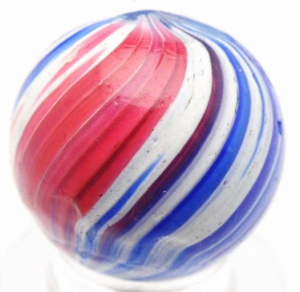 360° Indian Style (Uncased Onionskin) Marble.: Base glass, as seen through pontils, is transparent light blue. 360° coverage of red, white, and blue coloring. One as-made surface indentations and pitting. Condition (9.4). Size 11/16" Dia.