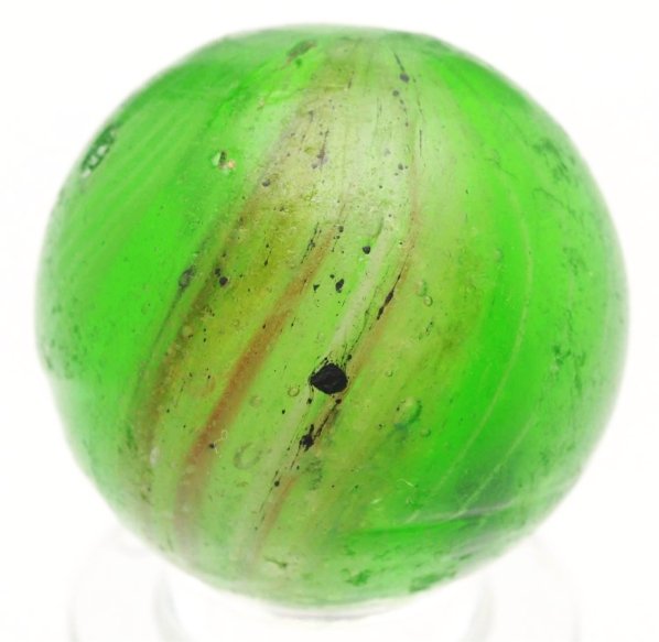 End of Cane Green Glass Latticino Swirl Marble.: Faceted pontil. Latticino breaks up in marble and some zigzag back to the pontil. Surface shows wear, one small as-made surface blowout, minor pitting, and some flea bites. Condition (8.7). Size 13/16