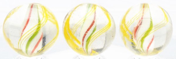 Lot of 3: Same Cane Solid Core Swirl Marbles.: Same cane marbles with white bases and alternating red and green bands. Outer decoration consists of yellow latticino threads in groups of three. One marble has as-made surface debris. Condition (9.1)