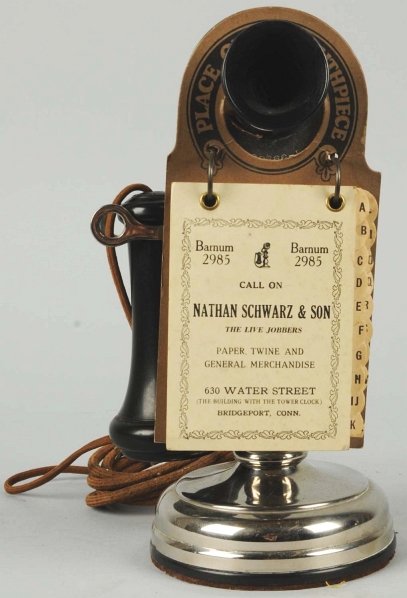 Kellogg Stick Telephone with Hanging Directory.: Circa 1910, nickeled brass with Bakelite sleeve, marked transmitter and receiver, unused Nathan Swartz & Son (Bridgeport, CT) attachment. Condition (Excellent). Size 11" T.