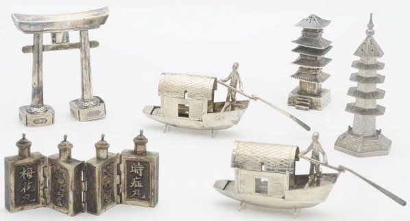 A Group of Straits Chinese Silver Condiments.: Including two pagoda salt casters, one marked STERLING; a pair of houseboats with opening roofs; a pepper caster in the form of a gate; and a set of four small flasks hinged together. Height of caster