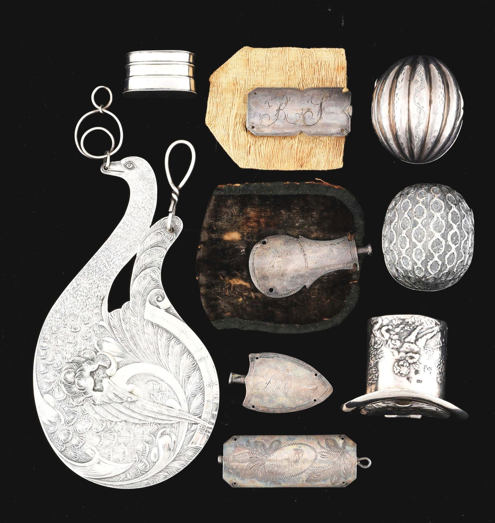 LOT OF 9: ANTIQUE SILVER ITEMS.: Lot of nine antique silver items. (A) A figural swan hanging postal scale, embossed, 4 - 3/4" long. (B) Four nutmeg graters: one oblong, 1" long; walnut shape; hat shape, embossed with cupids, no grat