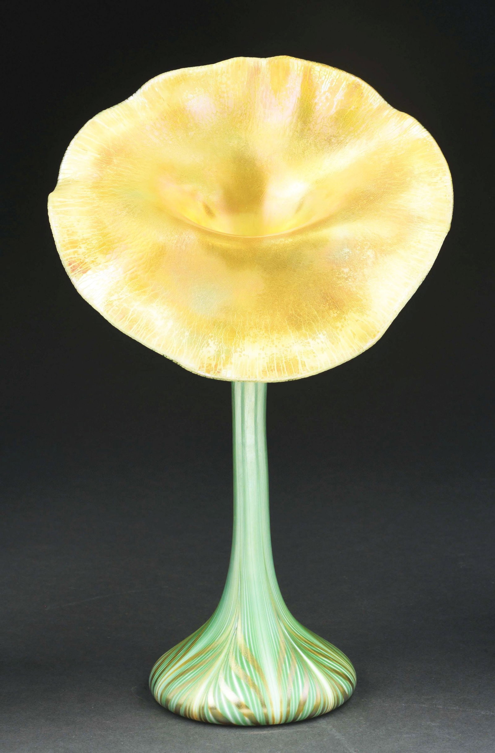 QUEZAL JACK-IN-THE-PULPIT VASE.: A beautiful and highly detailed vase by Quezal. The 12" tall vase has a Jack-in-the-Pulpit form with green pulled-feather motif. The mouth of the flower is ruffled with iridescent gold glass. The unde