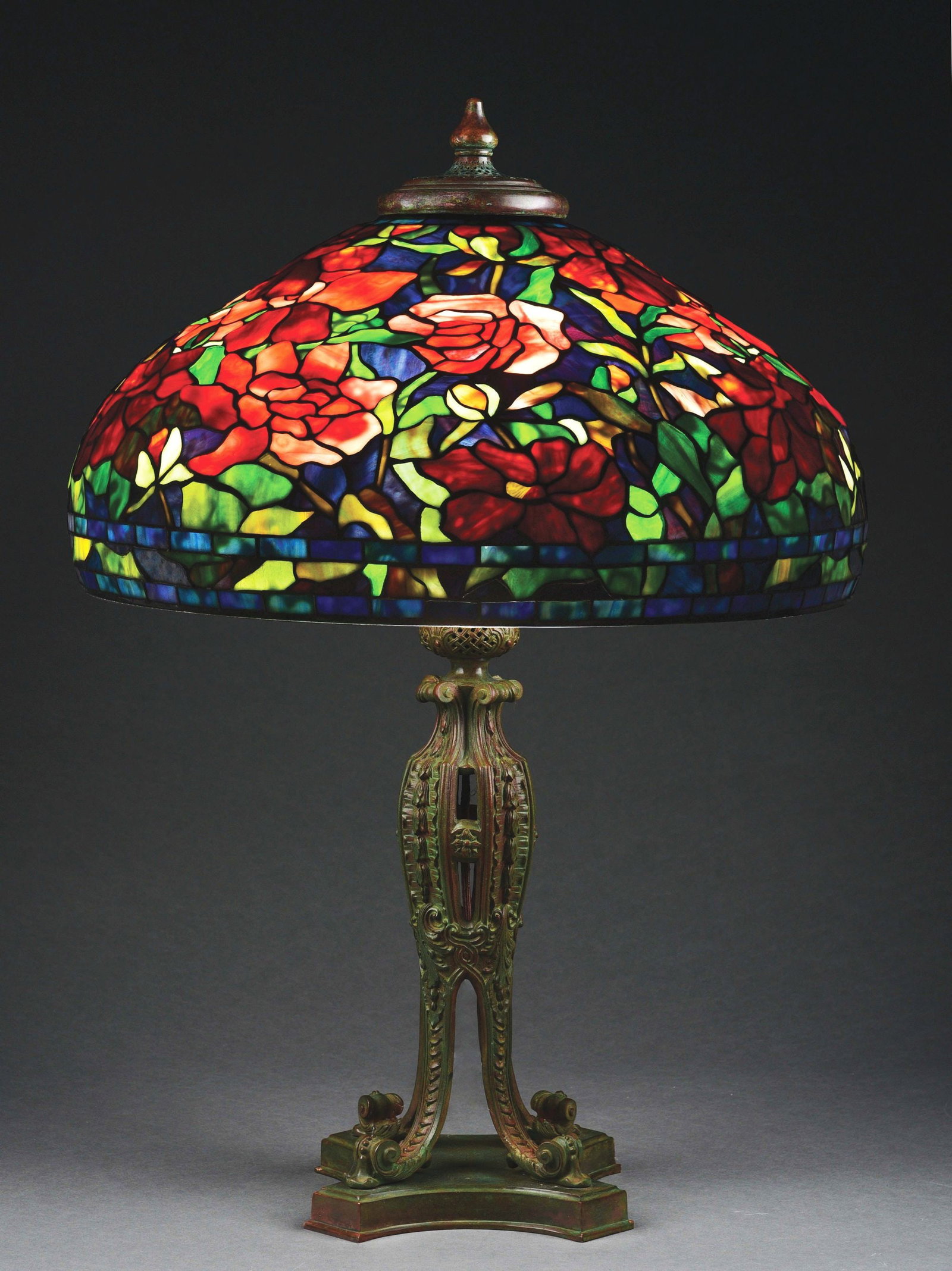 TIFFANY STUDIOS STYLE 22" PEONY LEADED GLASS LAMP.: A beautiful reproduction of a Tiffany Studios 22" peony in the style of Tiffany Studios or Paul Crist. The 22" shade has a peony pattern with a background of beautifully streaked purple glass. The flo