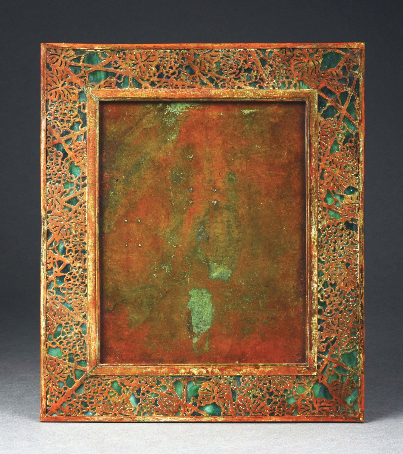 TIFFANY STUDIOS LARGE GRAPEVINE PICTURE FRAME.: An absolutely gorgeous picture frame by Tiffany Studios. The 14" tall frame features green slag glass, which is highly mottled and scummed. There are areas of blue highlights throughout. Frame has pat