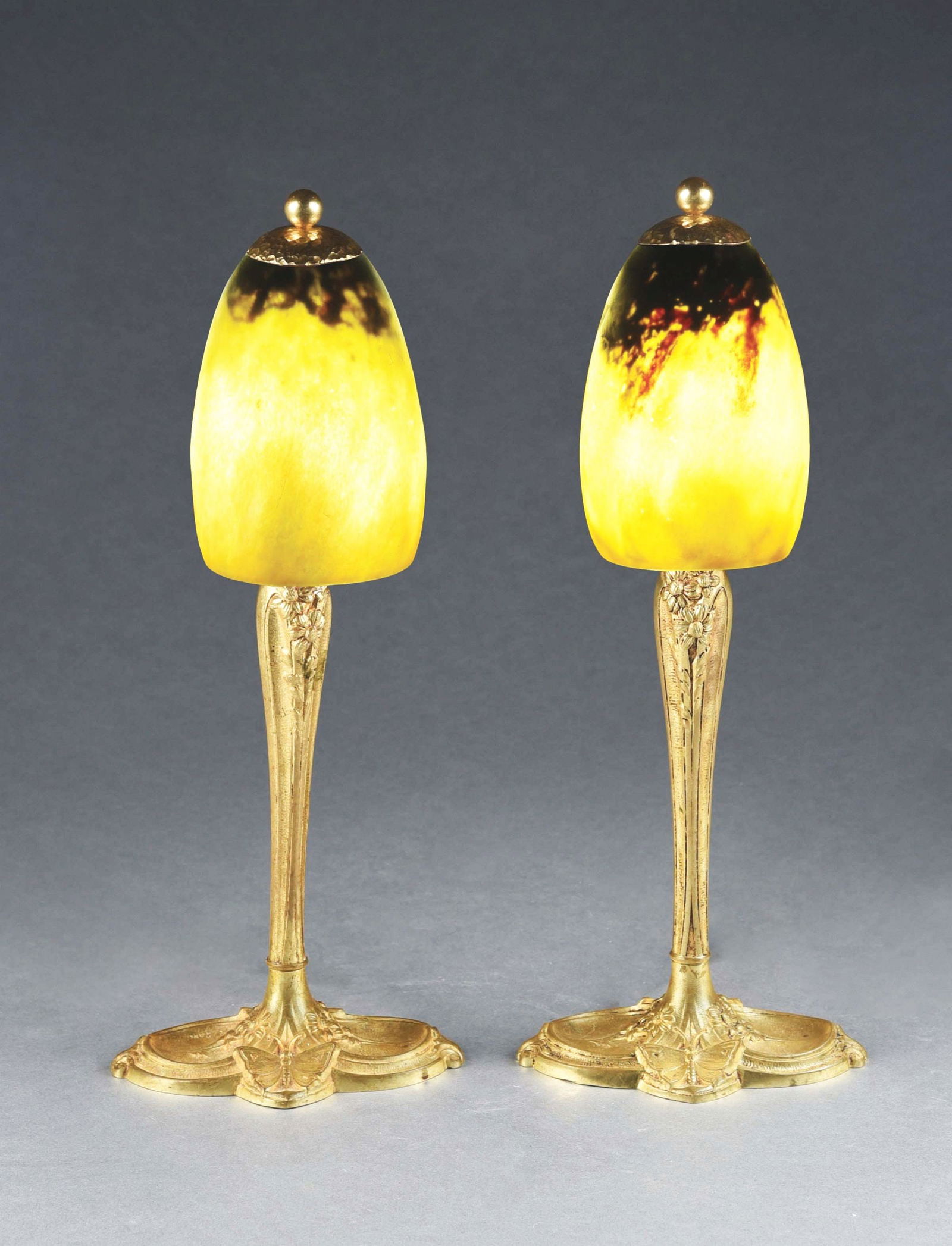 PAIR OF DAUM NANCY BOUDOIR LAMPS ON CHARLES RANC BASES.: A lovely matching pair of art deco boudoir lamps. Each lamp stands 15" tall, and has a glass shade with mottled yellows, oranges and purples. Shades are signed, "Daum Nancy." Each shade sits on a gilt