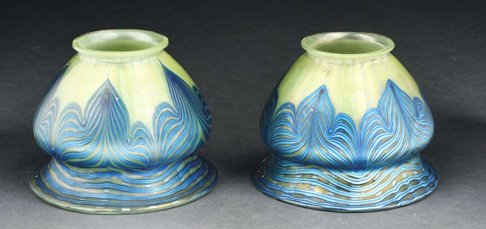 LOT OF 2: LOETZ ART GLASS SHADES.: Two early 20th century art glass shades by Loetz. Each shade stands 3 - 1/2" tall and has a frosted yellow background with oil spot pattern. It is further decorated by a swirling iridescent blue desig