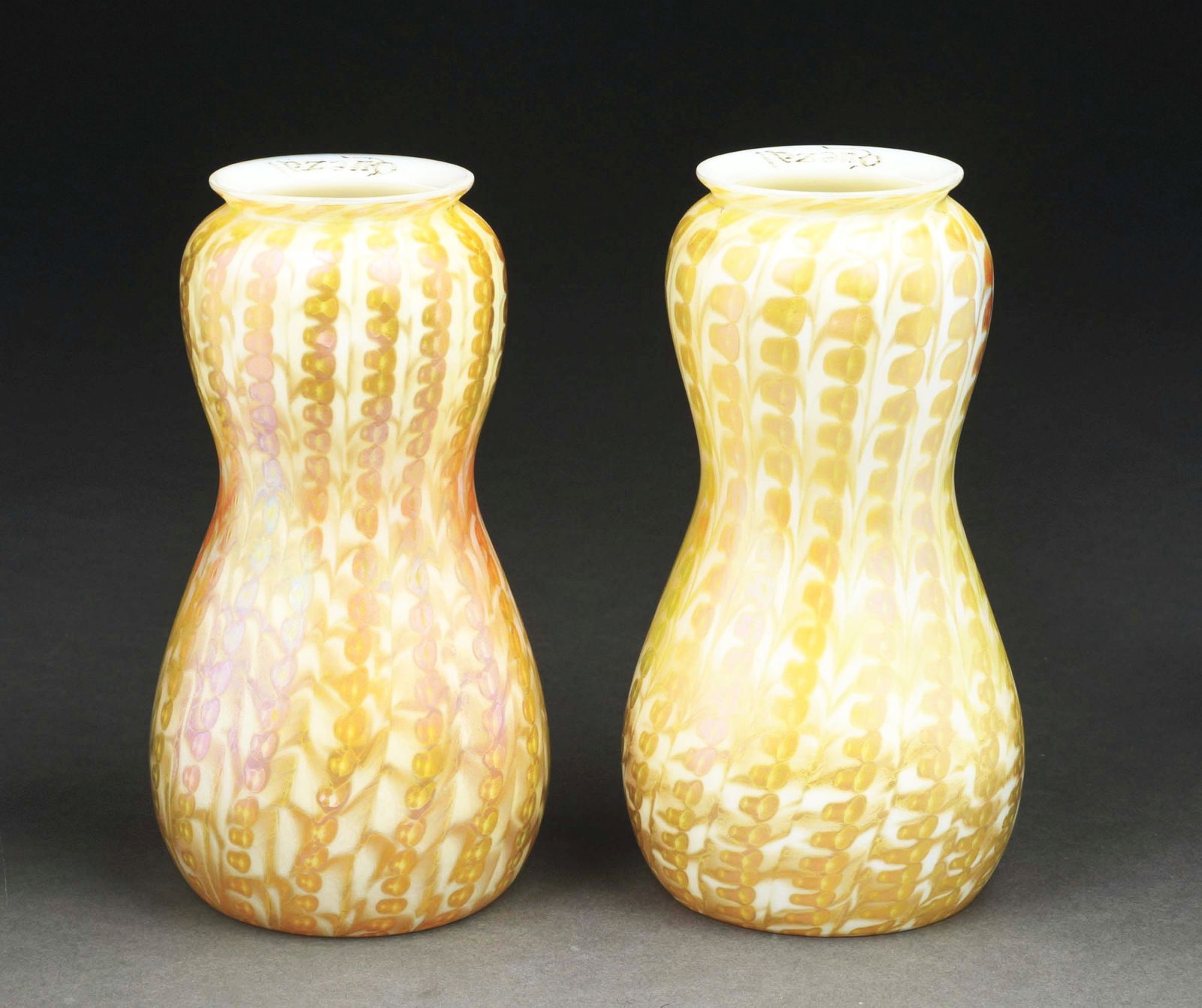 LOT OF 2: QUEZAL ZIPPER SHADES.: A lovely matching pair of Quezal shades. Both 6-1/2" tall, gourd-shaped shades feature a zipper pattern. Both shades are properly signed "Quezal" to the fitter edge. CONDITION: Both are in excellent c