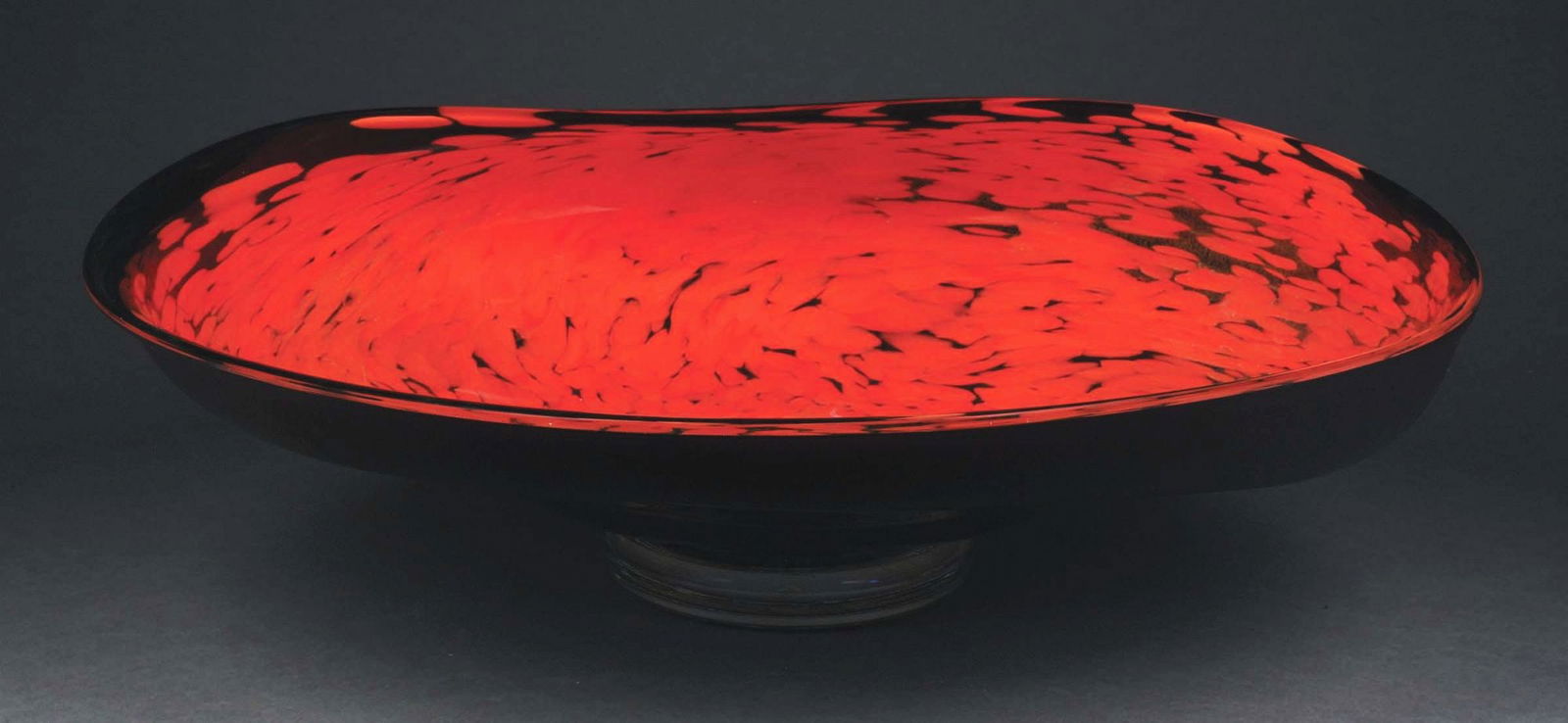 MONUMENTAL CLAM SHELL ART GLASS BOWL.: A beautiful and massive signed blown art glass bowl by Taylor Backes. The bowl has a stylized clam shell form with a black background, and prominent red oil spot pattern with iridescent dusting patter