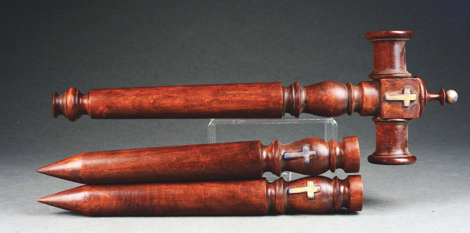 EUROPEAN VAMPIRE HAMMER WITH 2 STAKES AND WOODEN CROSS.: A set consisting of a vampire killing hammer and two stakes made of walnut, with mounted bronze or brass crosses. All three pieces have hardware mounted on the back. CONDITION: Overall, in excellent c