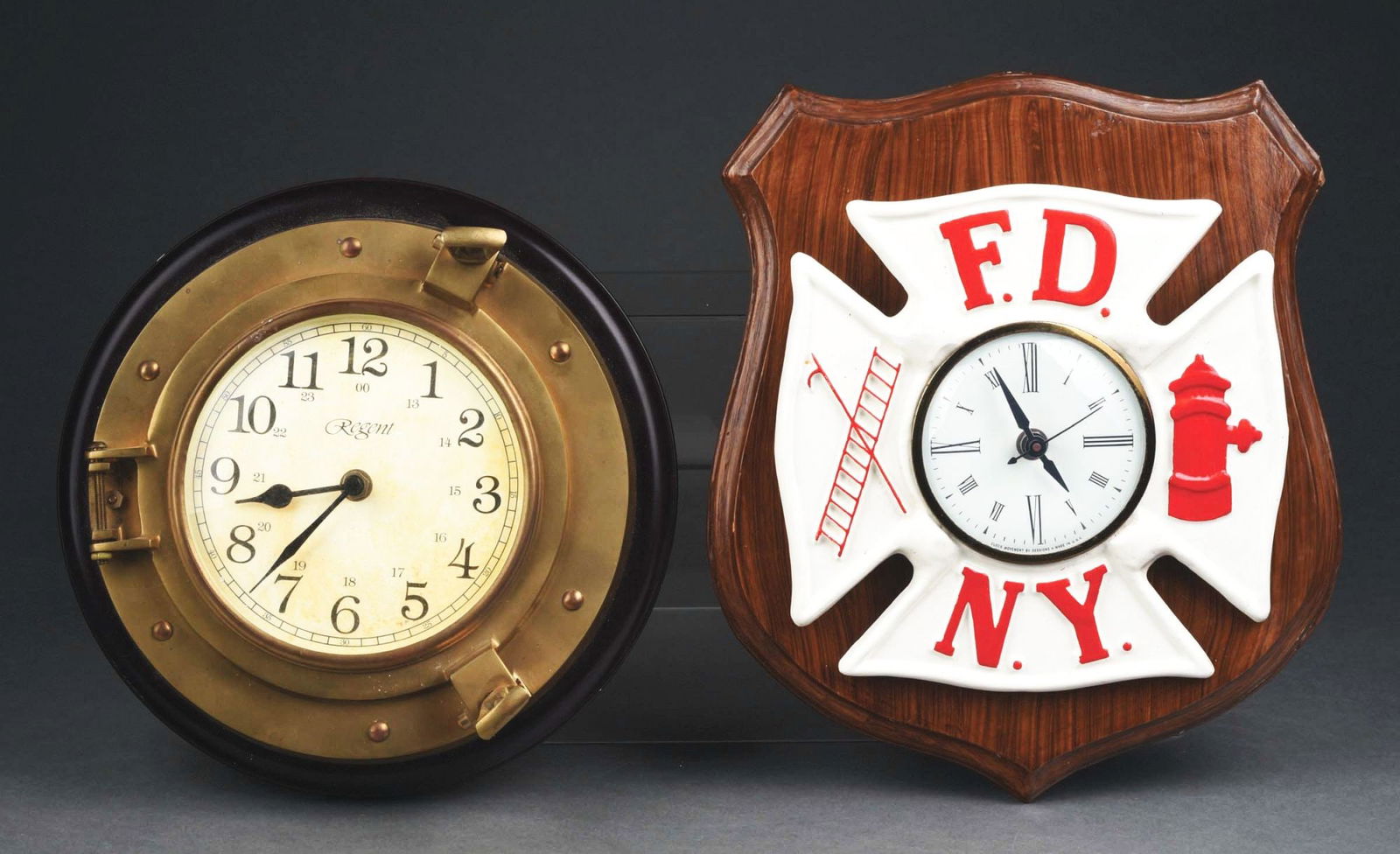 LOT OF 2: BATTERY-OPERATED CLOCKS.: (A) New York Fire Department porcelain on wooden plaque, 10" by 10". (B) Regent brass clock on wooden plaque, 10" dia. Condition: (Excellent). Item Dimensions: Each: 10" Dia.