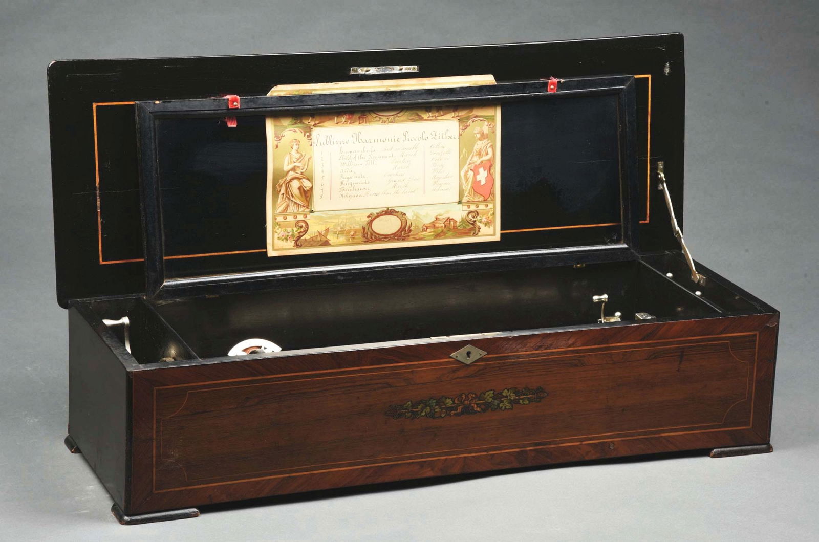 19TH CENTURY CYLINDER MUSIC BOX WITH 8-TUNE SUBLIME HARMONIC PICCOLO ZITHER: A very nice example of this swiss music box playing a 17-1/2" cylinder with 8 tunes. 2 combs with a Sublime Harmonic Piccolo Zither attachment. Anchor mark on the comb and cast iron plate. CONDITION: