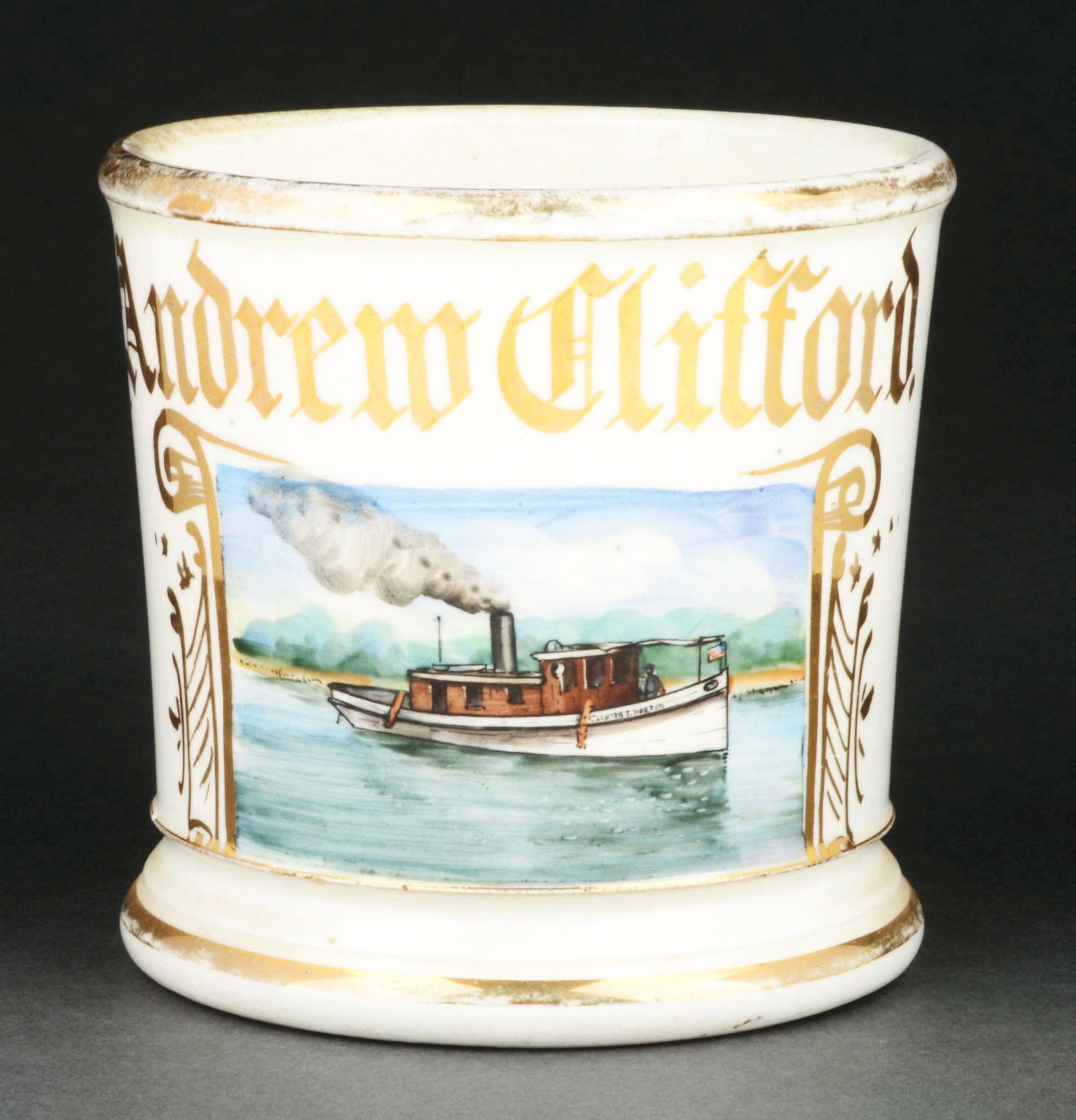 STEAM BOAT DRIVER SHAVING MUG.: Has the name "Andrew Clifford" in gold gilt. Nice image of man operating steam-driven boat. Condition: (Excellent). Item Dimensions: 4 - 1/2" x 3 - 1/2" x 3 - 1/2".